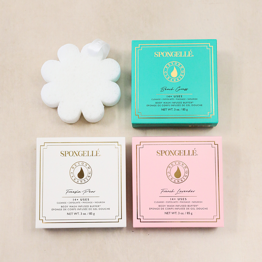 Flower-shaped bath sponge set with three Spongellé boxes in teal, white, and pink.