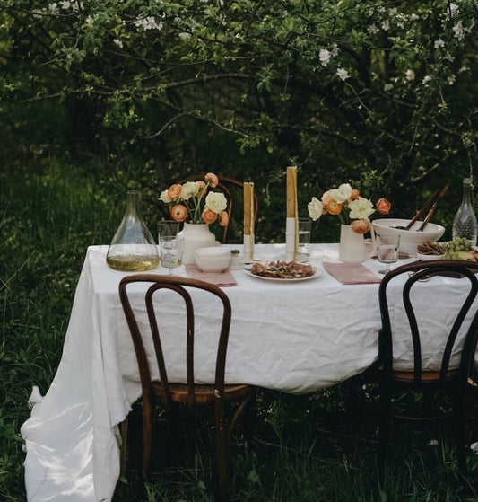White linen tablecloth draped over an outdoor dining table