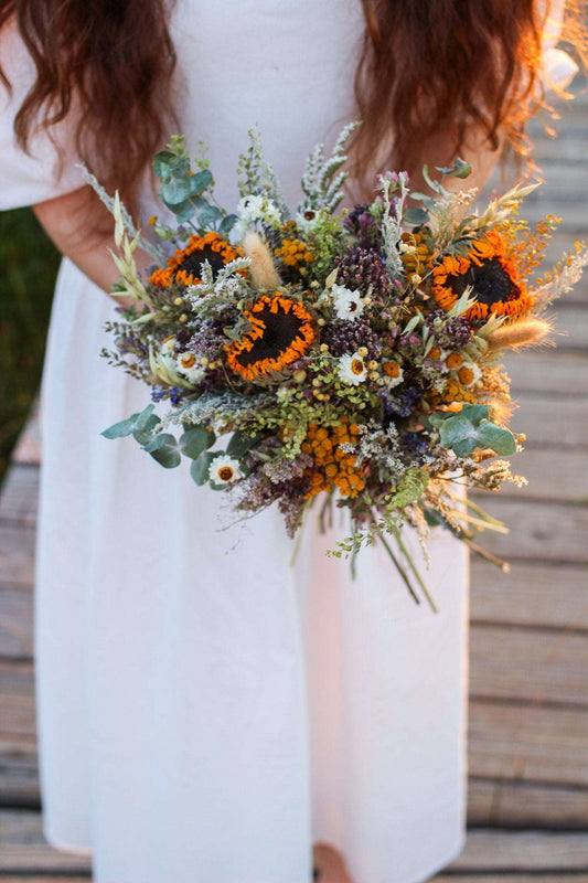 Dried floral bouquet with orange sunflowers, white daisies, and leafy greenery