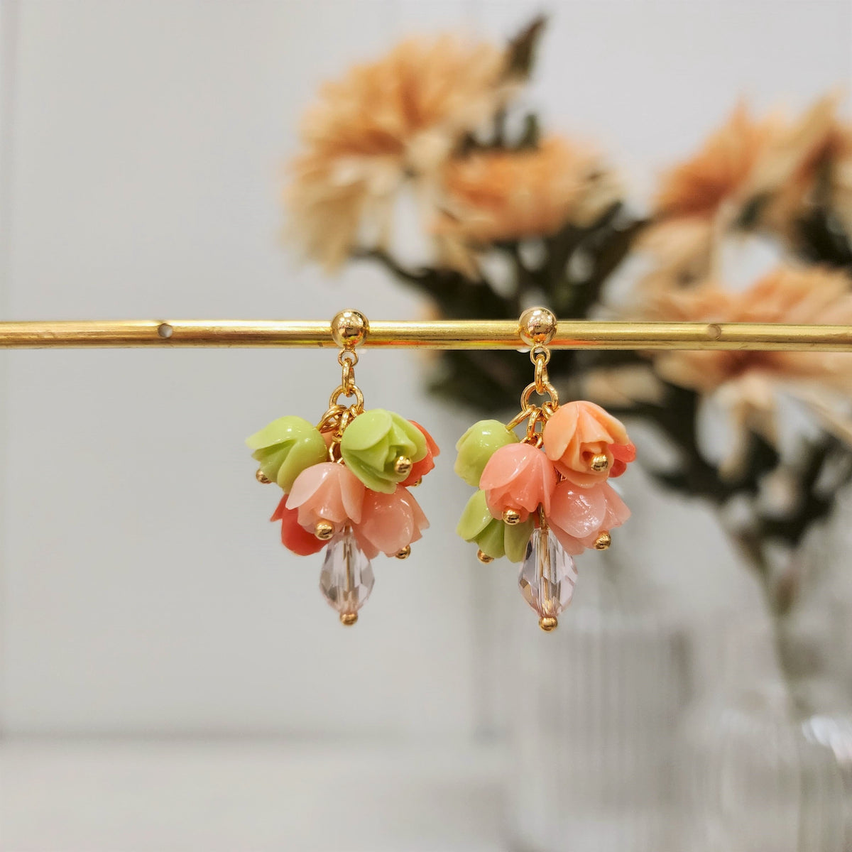 Gold-tone tulip bouquet dangle earrings with green and peach-pink flower clusters