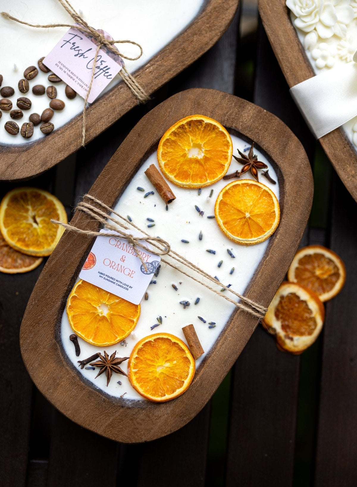 Soy candle in wooden dough bowl with orange slices, anise star, and spice seeds