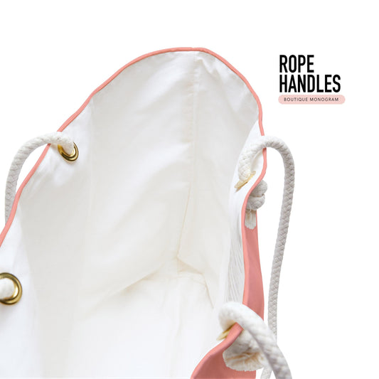 Tote bag detail with thick white rope handles, metal grommets, and coral edge trim