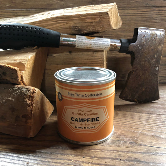Orange soy candle in metal tin on wooden surface, lid closed