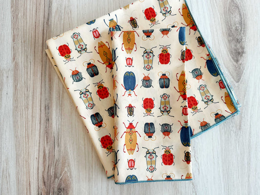 Cloth napkins with beetle and ladybug pattern, blue border stitching