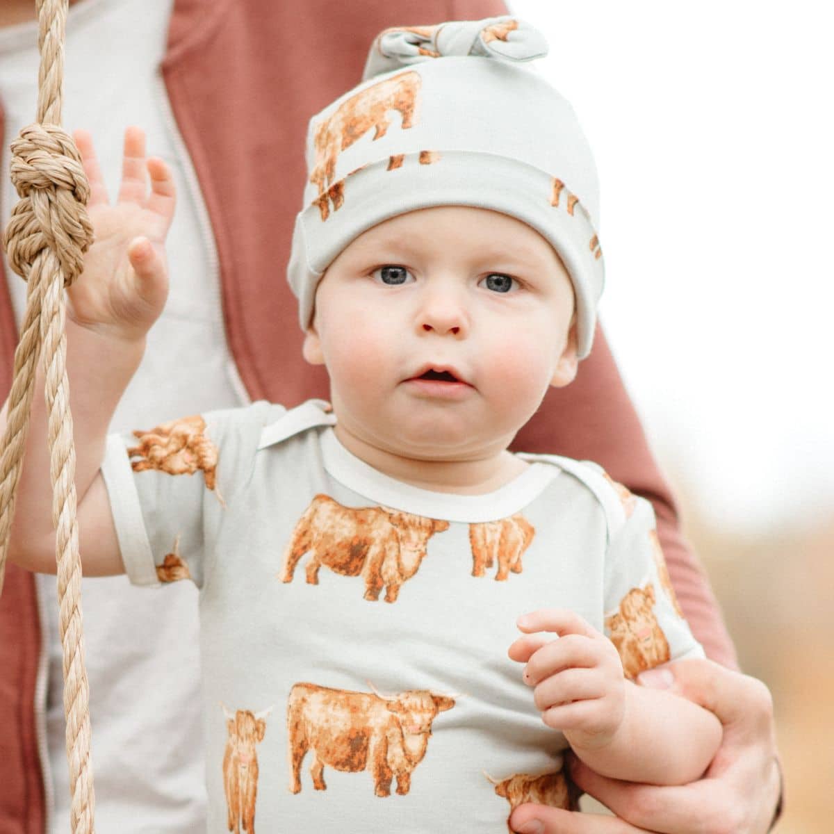 Cream knotted beanie hat with animal pattern and ribbed cuff on baby