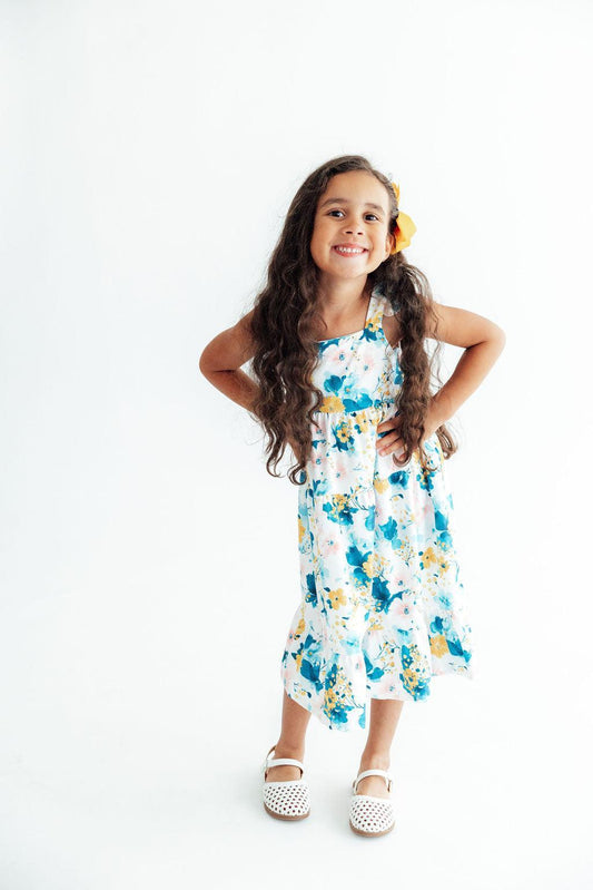 White ruffle maxi dress with blue and yellow floral print, tiered skirt, ruffle shoulders