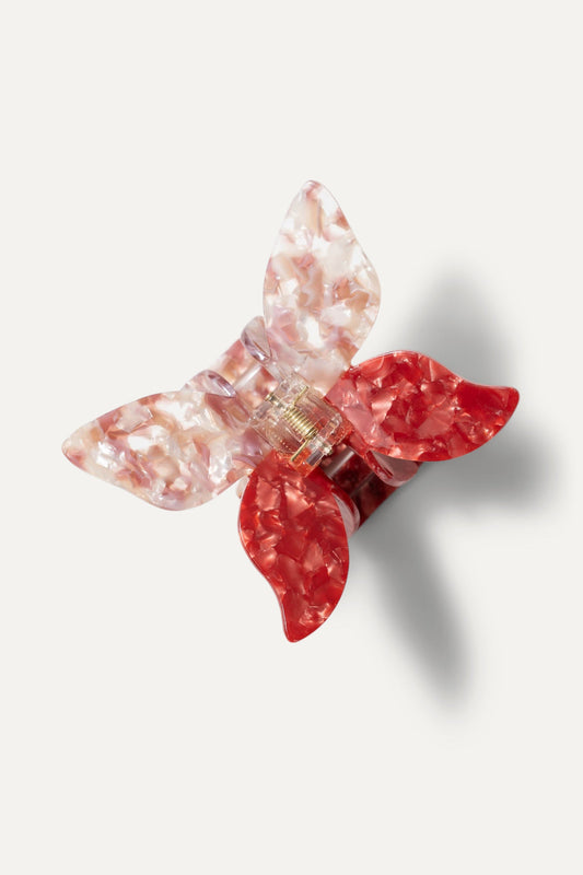 Butterfly hair claw accessory with translucent pink wings and ruby red center, gold clasp