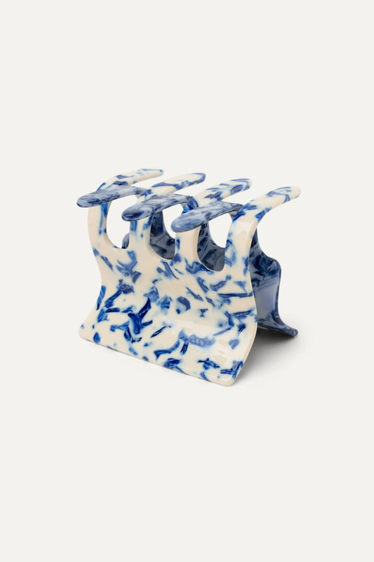 Delft blue patterned hair claw with white base, curved prongs for holding hair
