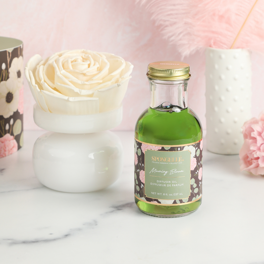 Morning Bloom diffuser oil bottle with green liquid beside flower-shaped diffuser base