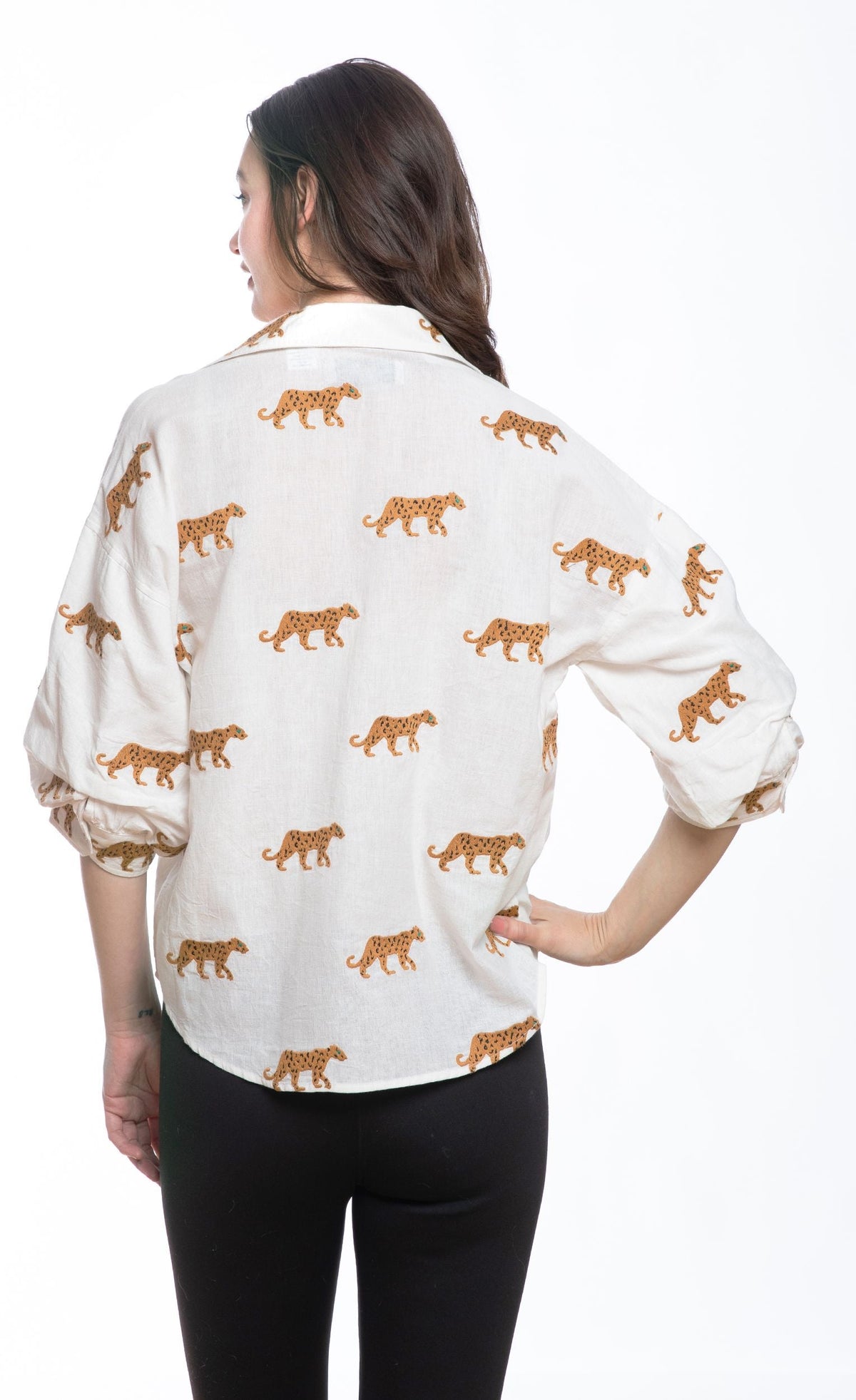 Back view: ivory embroidered cheetah print blouse with red-button placket and gathered hem