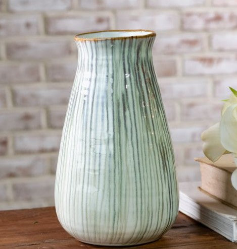 Ceramic vase with tall curving shape, vertical green-and-white stripes, flared top