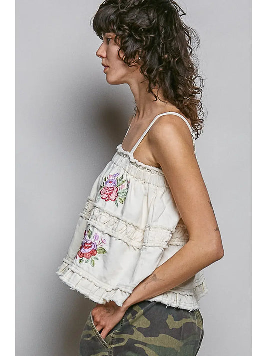 Side view of an ivory embroidered tank with floral motifs and layered ruffle trim