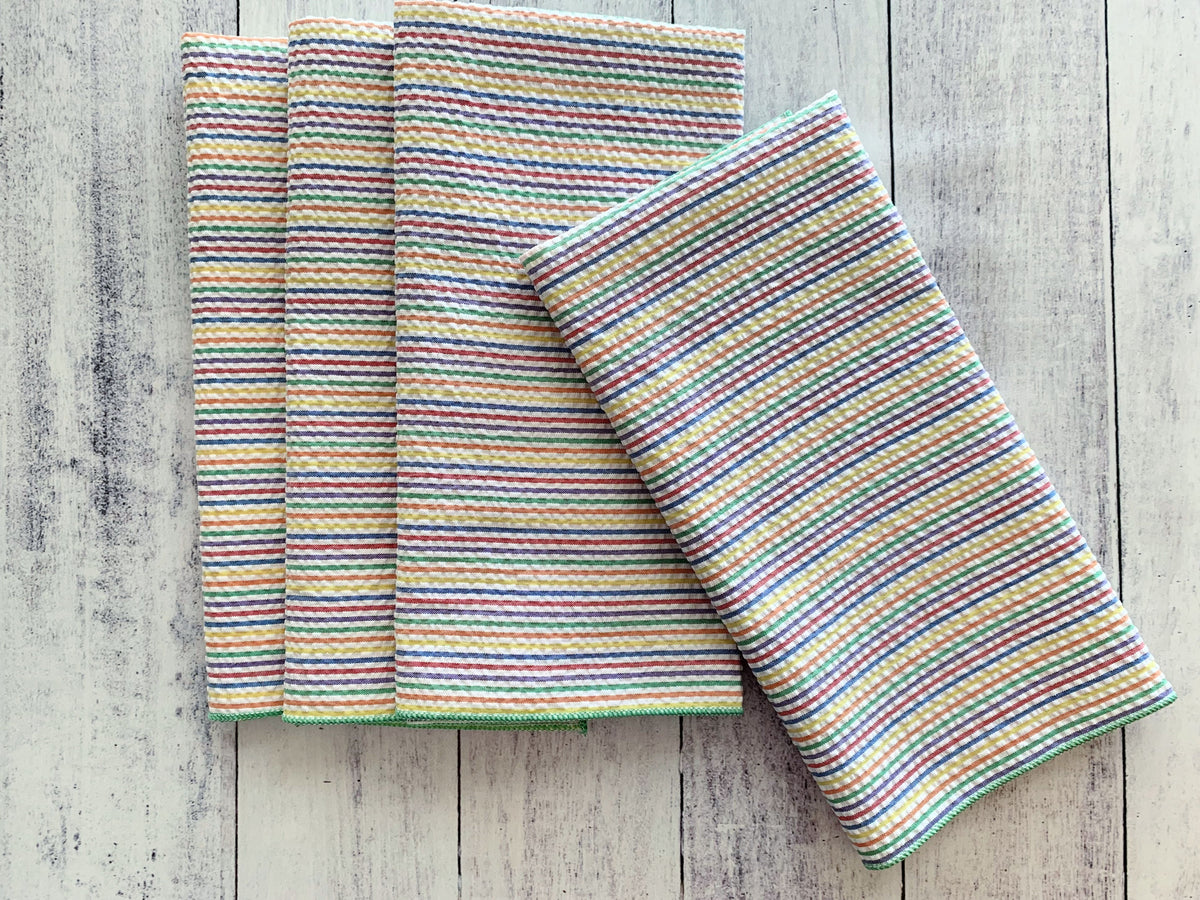 Rainbow striped seersucker napkins set of four, neatly folded with one angled