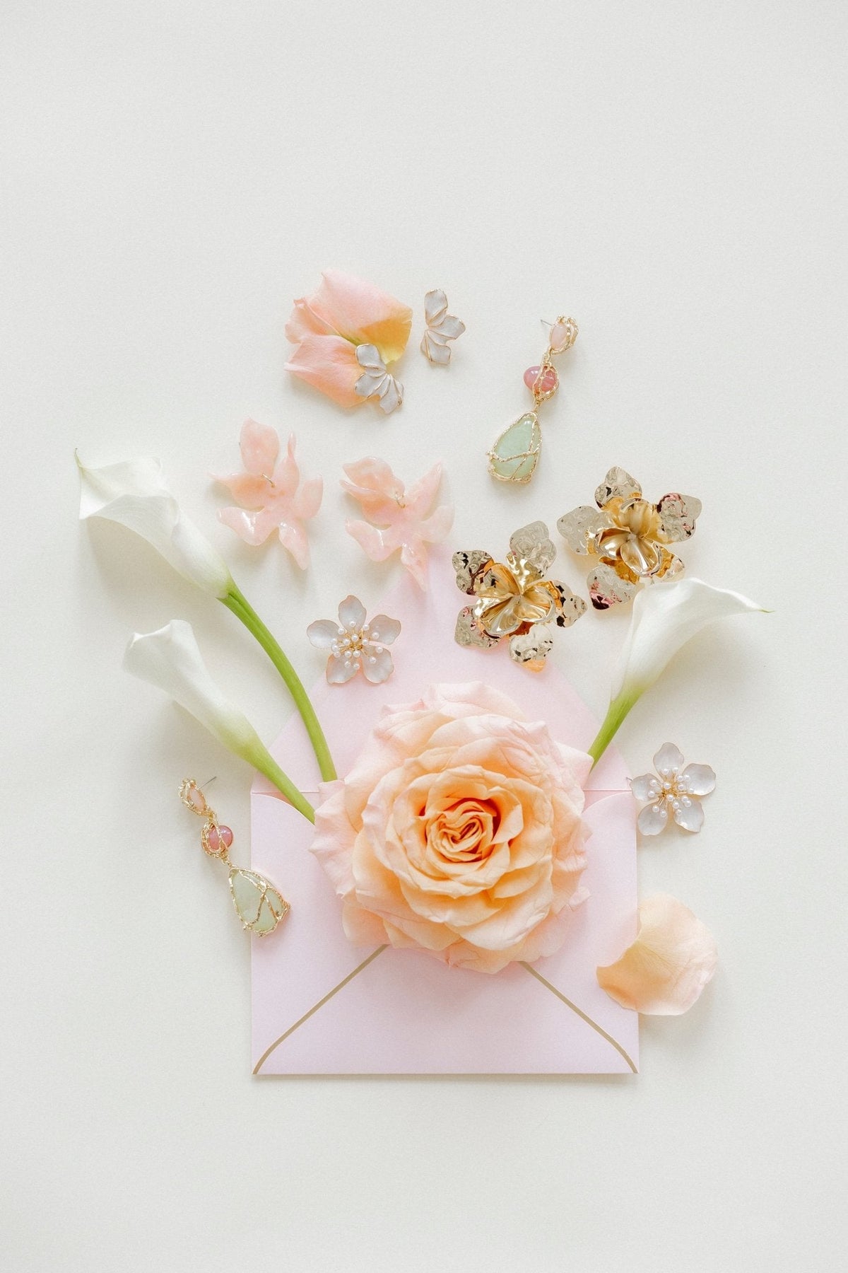 Statement earring set with gold-tone floral charms, pink teardrops, and green bead drops