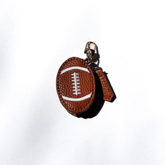 Brown leather sports bag charm ball with white laces on a gold keyring clip