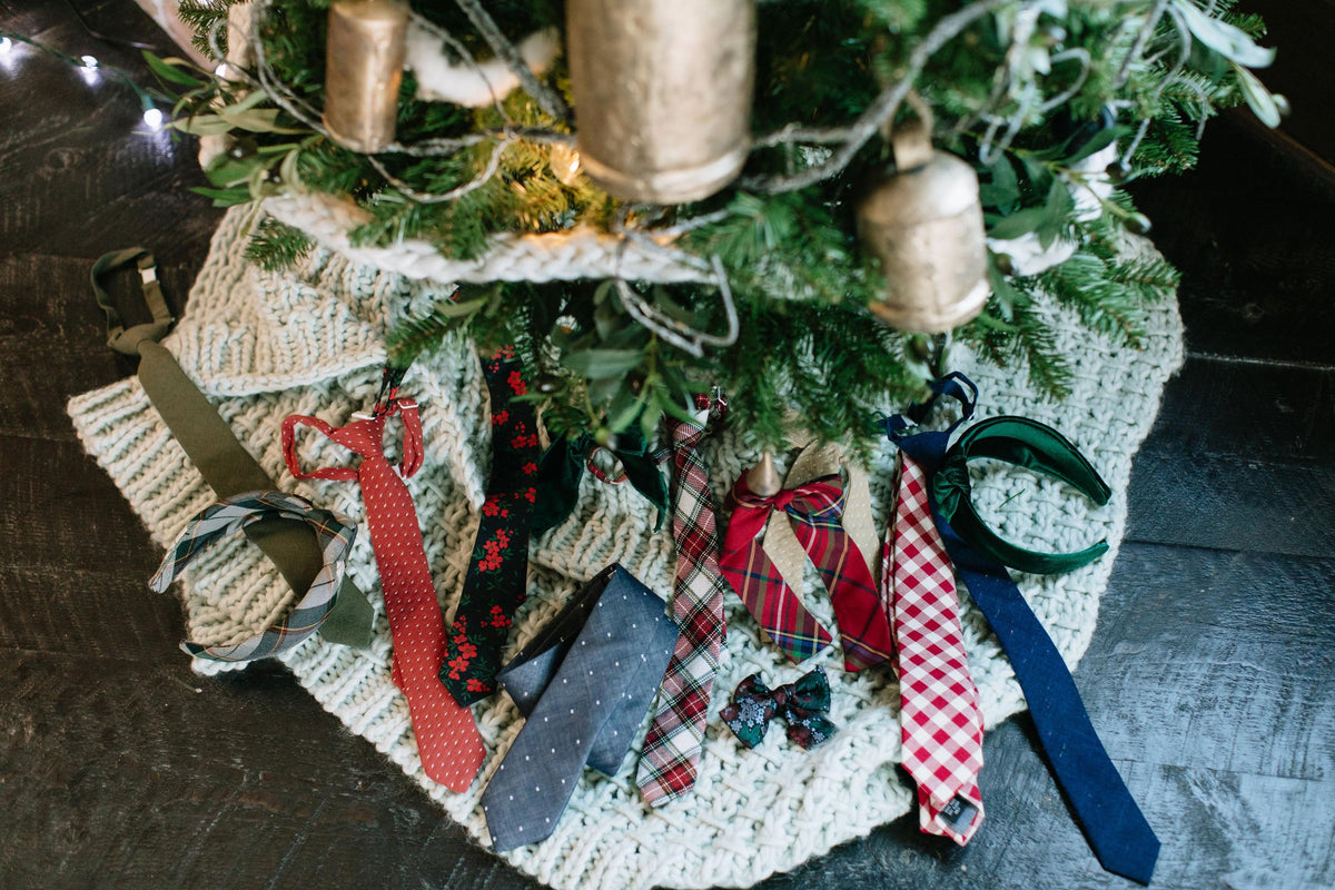 Plaid ribbon bows on holiday garland with dark green, red, and cream accents