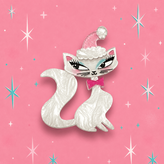 White cat brooch with pink cap, cloud trim, and pink bow with teal eyes