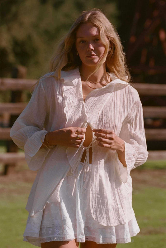Ivory tiered ruffle top with long sleeves and lace-up neckline ties