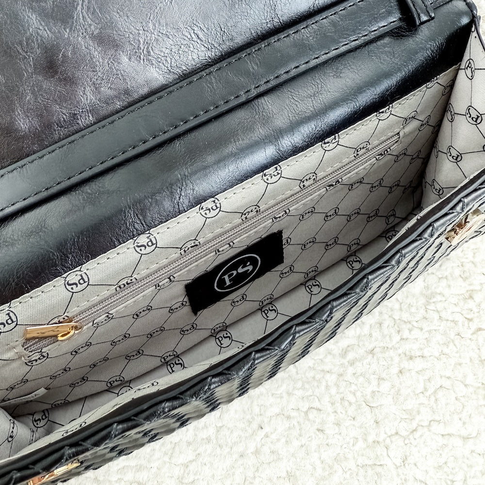 Open black foldover clutch interior with logo-pattern lining and inner pocket