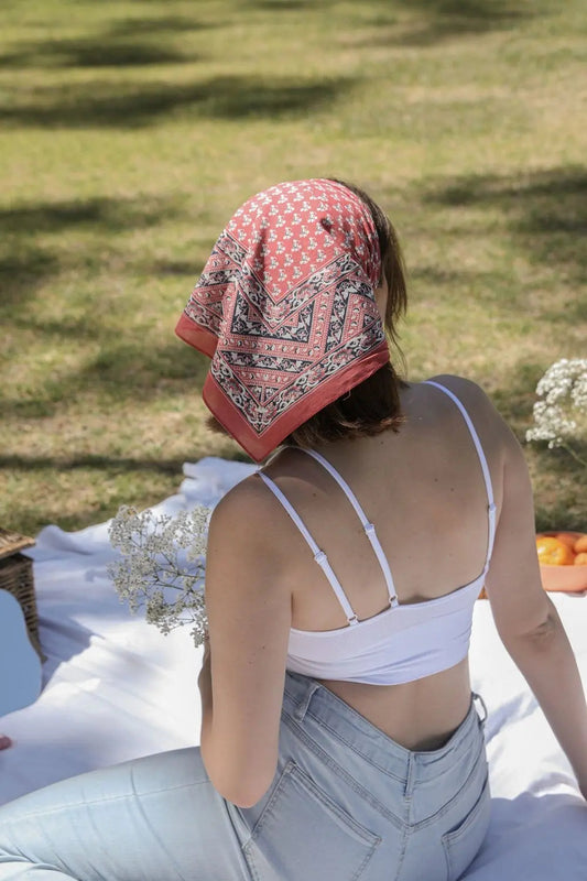 Vine motif bandana scarf, brick red with repeating motifs and paisley border, tied on head