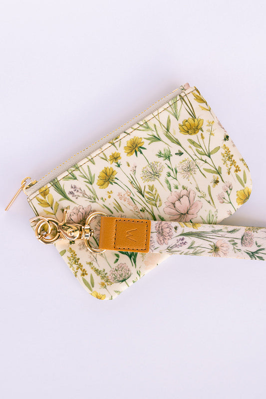 Floral triangle zipper pouch with gold zipper, keychain clip and tan leather tag