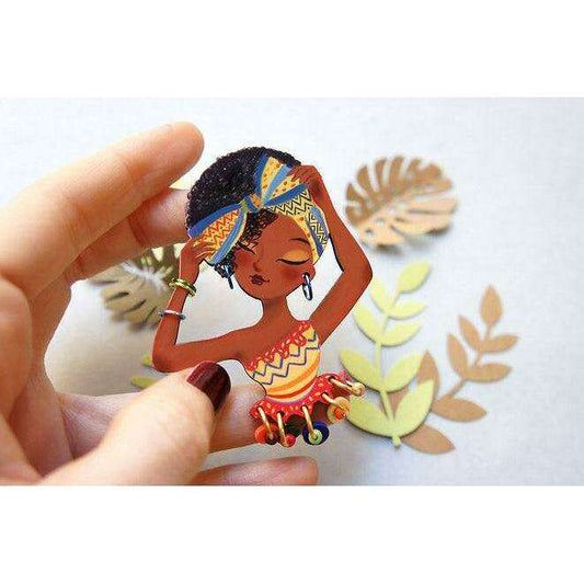 African woman brooch with raised hand, layered colors, and bead charm dangles