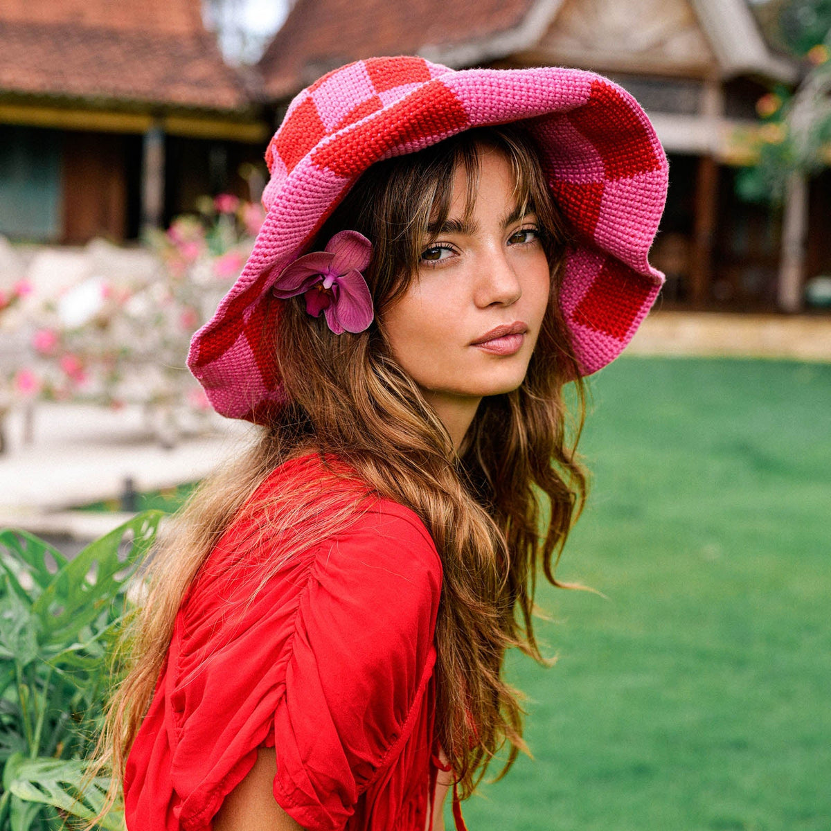 Red and pink checkered crochet bucket hat with side flower and wide brim