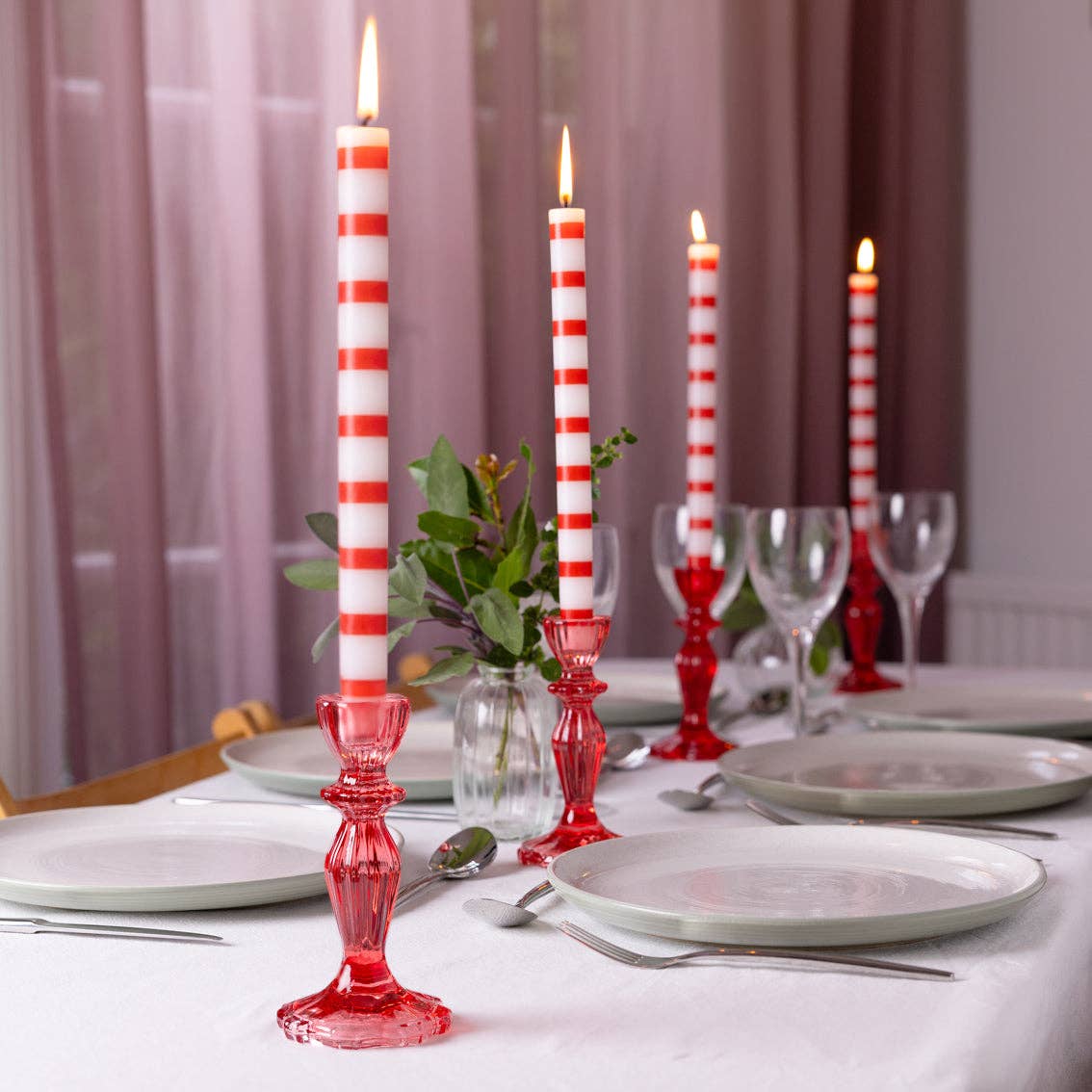 Red and white striped pillar candle in a clear glass holder