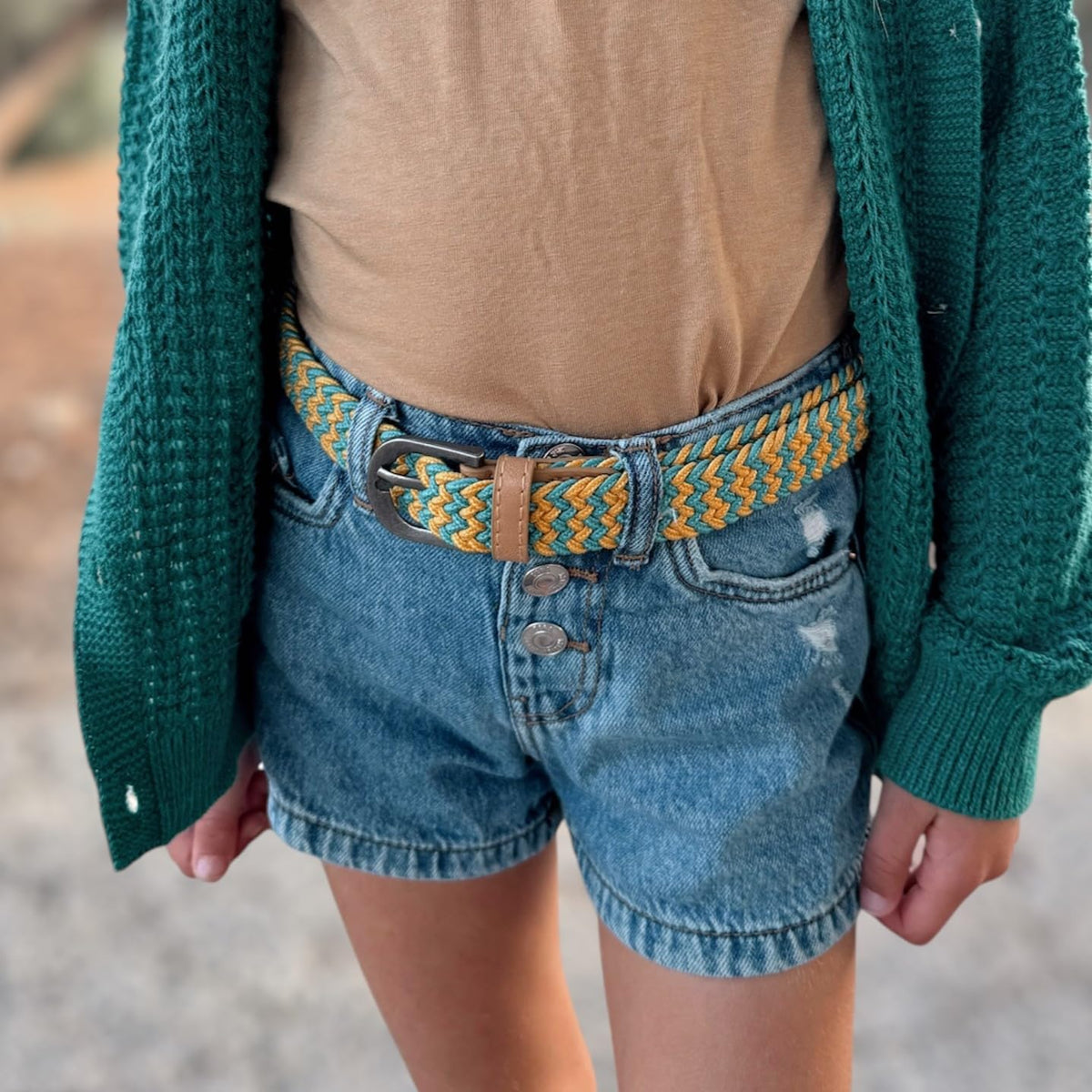 Yellow and blue braided stretch belt with tan leather trim, worn with denim shorts