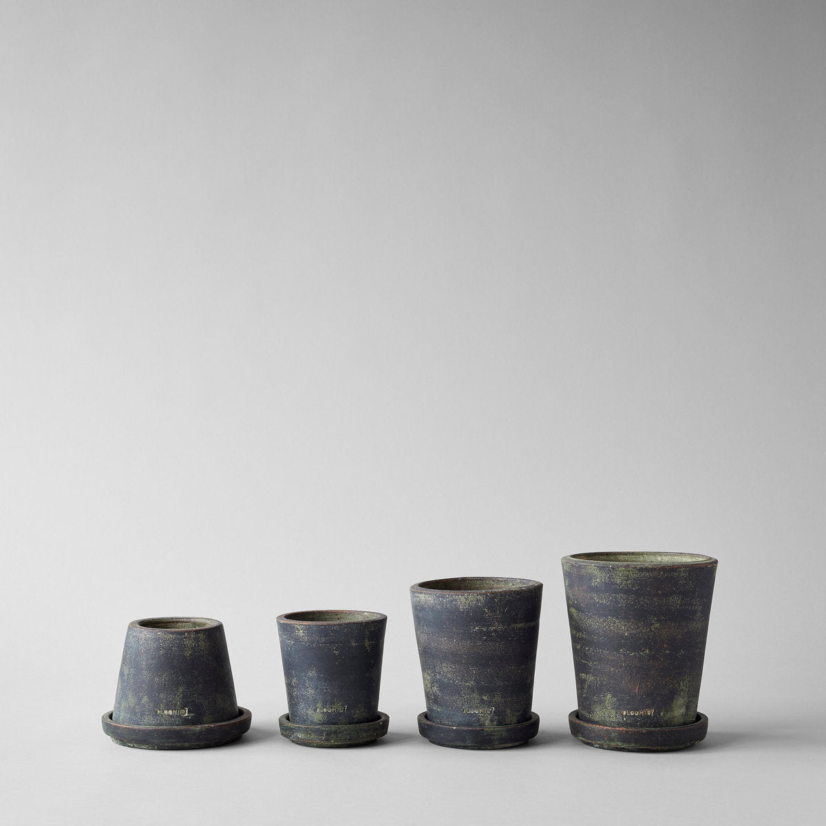 Set of four small planter pots in grey patina with flared rims