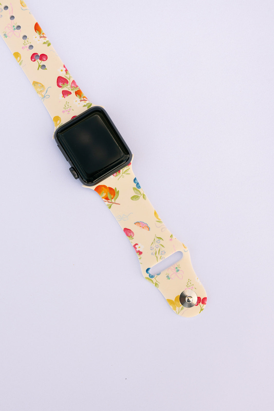 Floral watch strap with attached dark smartwatch, side view