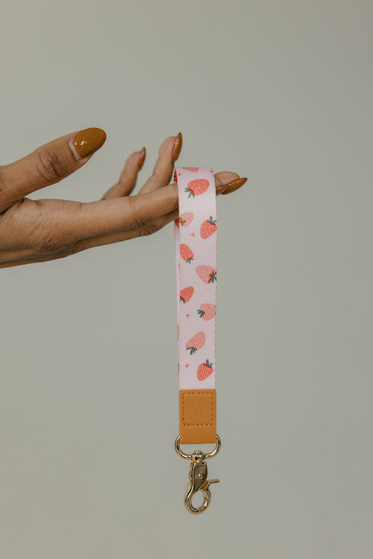 Strawberry wrist lanyard with tan end tab and gold keyring phone holder