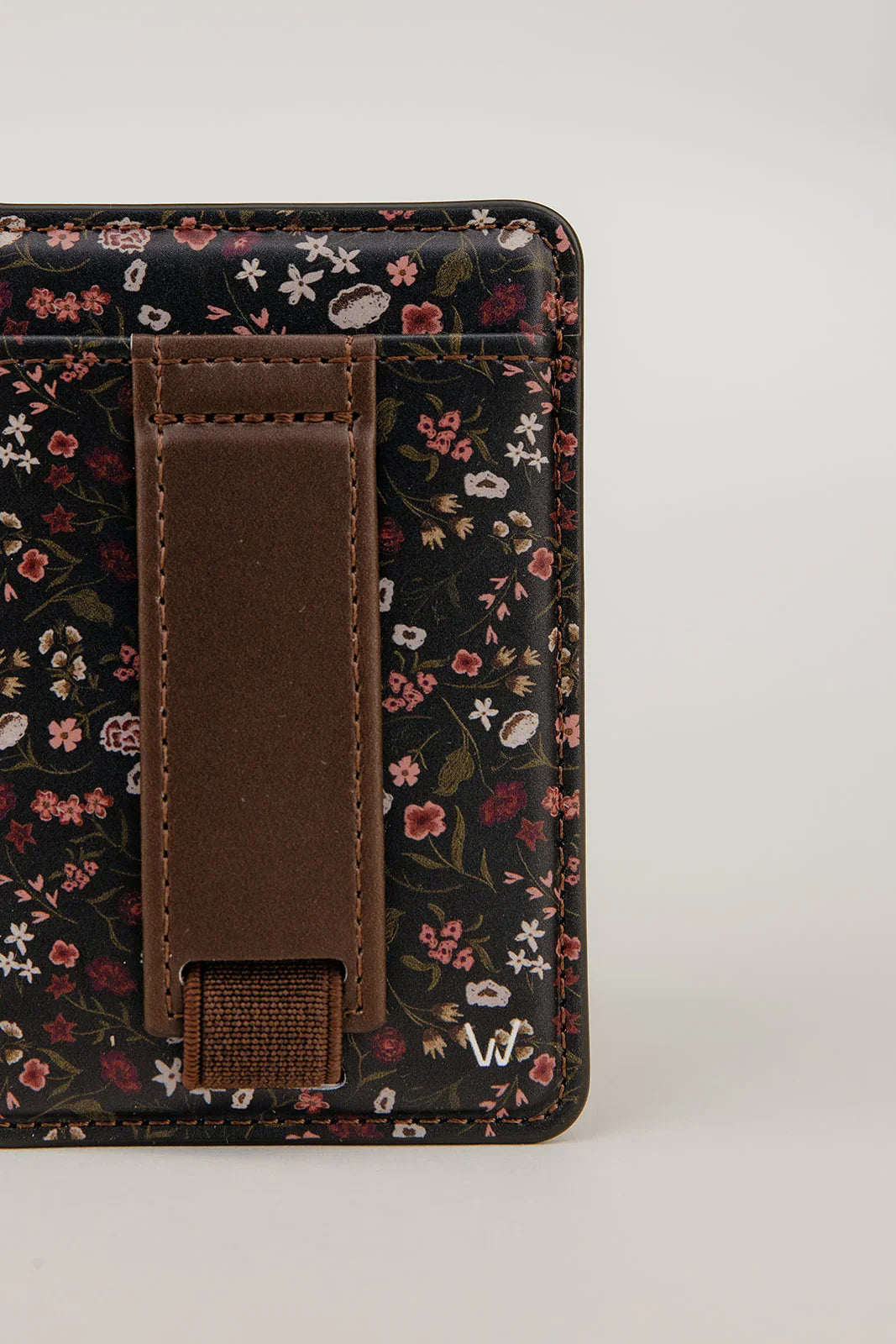 Magnetic wallet with dark floral exterior and brown magnetic strap, front view.