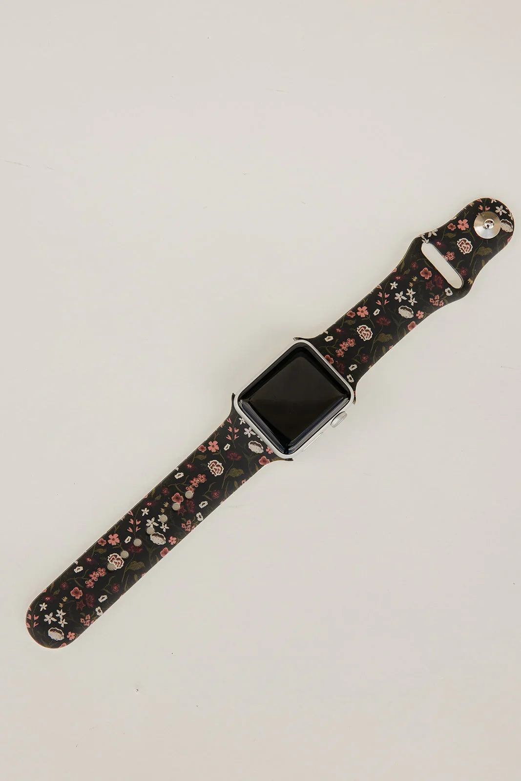Black floral watch band with square smartwatch case, laid flat
