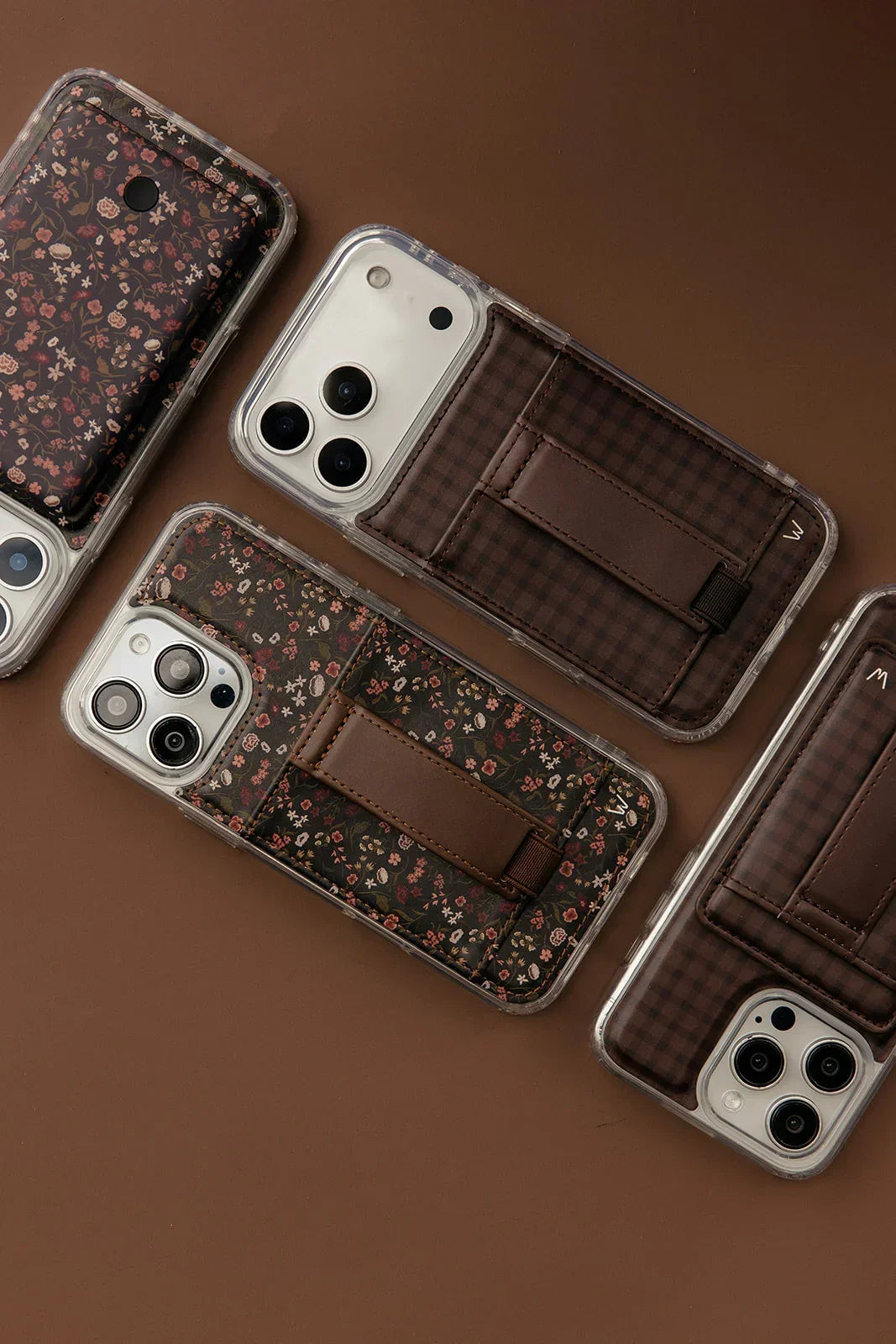 Multiple floral phone cases with clear covers and brown strap-pouch design