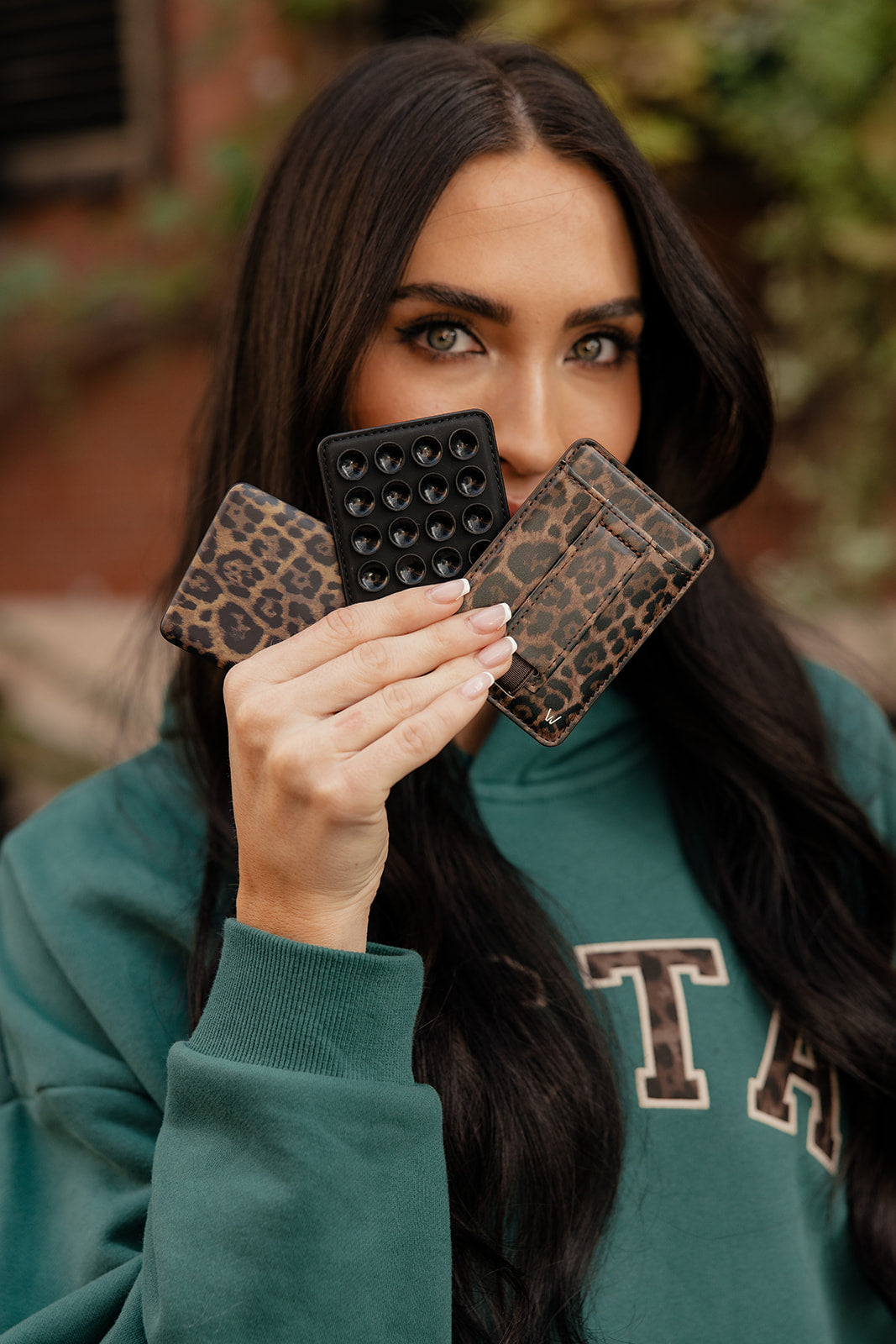 Leopard-pattern magnetic wallet phone case with card slots, shown with a phone