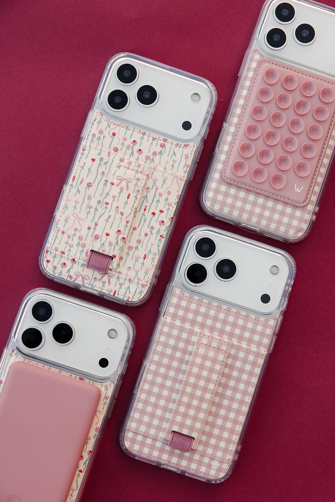 Five phone cases on pink background: gingham, rose vine, and pink pop-bubble patterns
