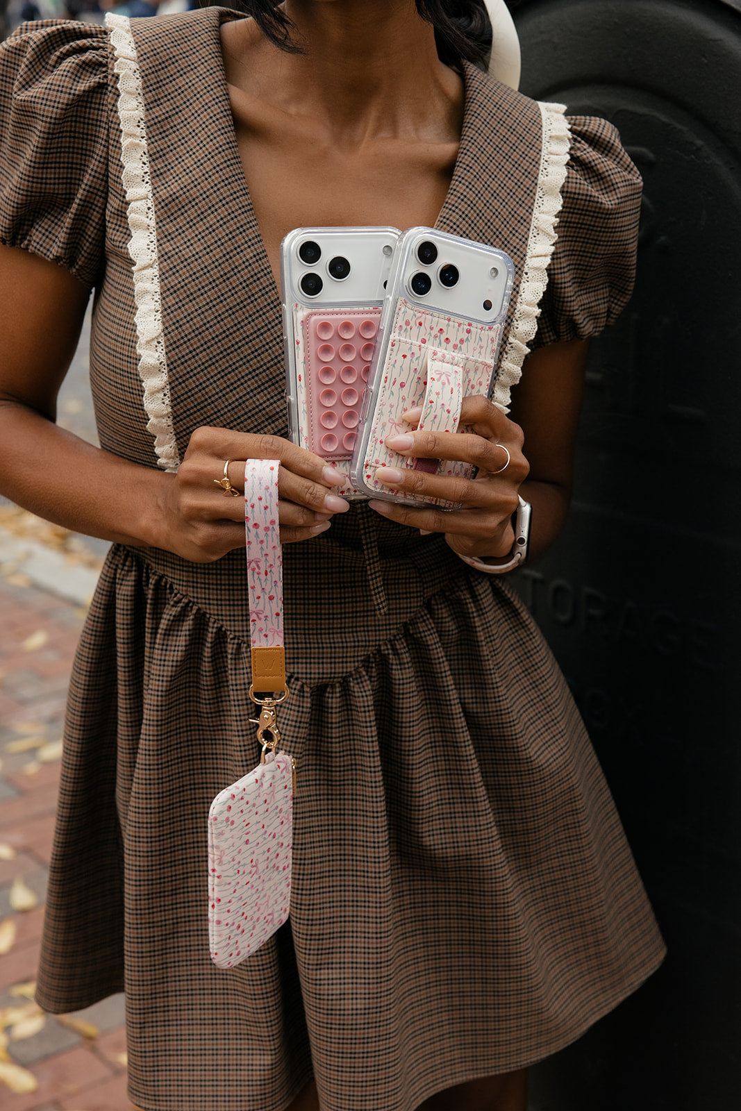 Pair of pastel phone cases: rose garden and pink pop-bubble pattern, worn with lanyards