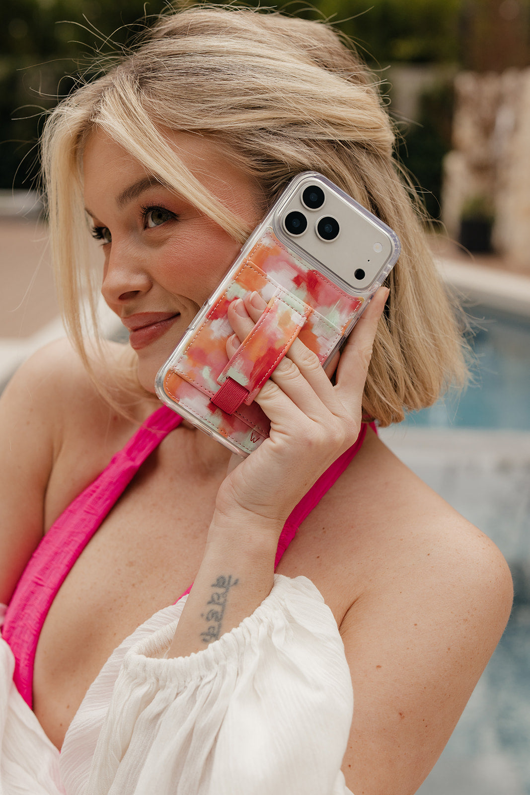 Watercolor orange and pink phone case with card pocket and wrist strap on phone