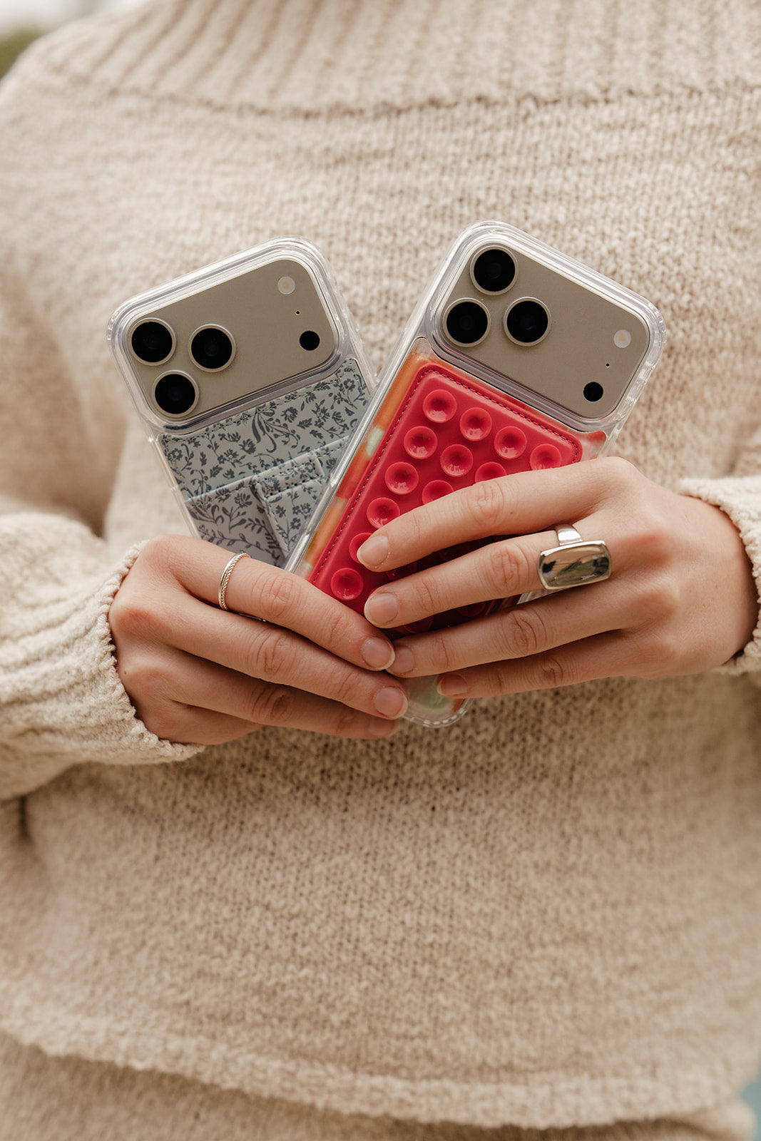Close-up of teal floral phone case with gray strap tab and clear camera bump cutouts