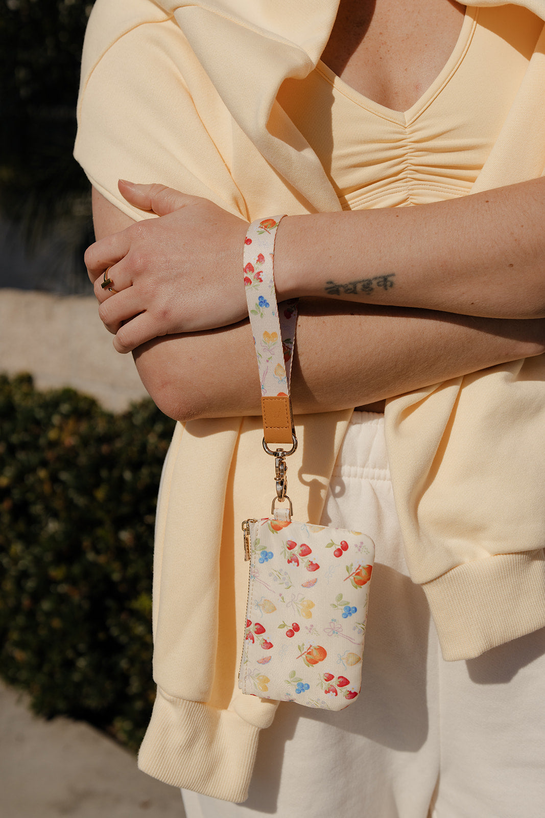 Berry-print wrist lanyard with small pouch, metal chain, and adjustable brown strap