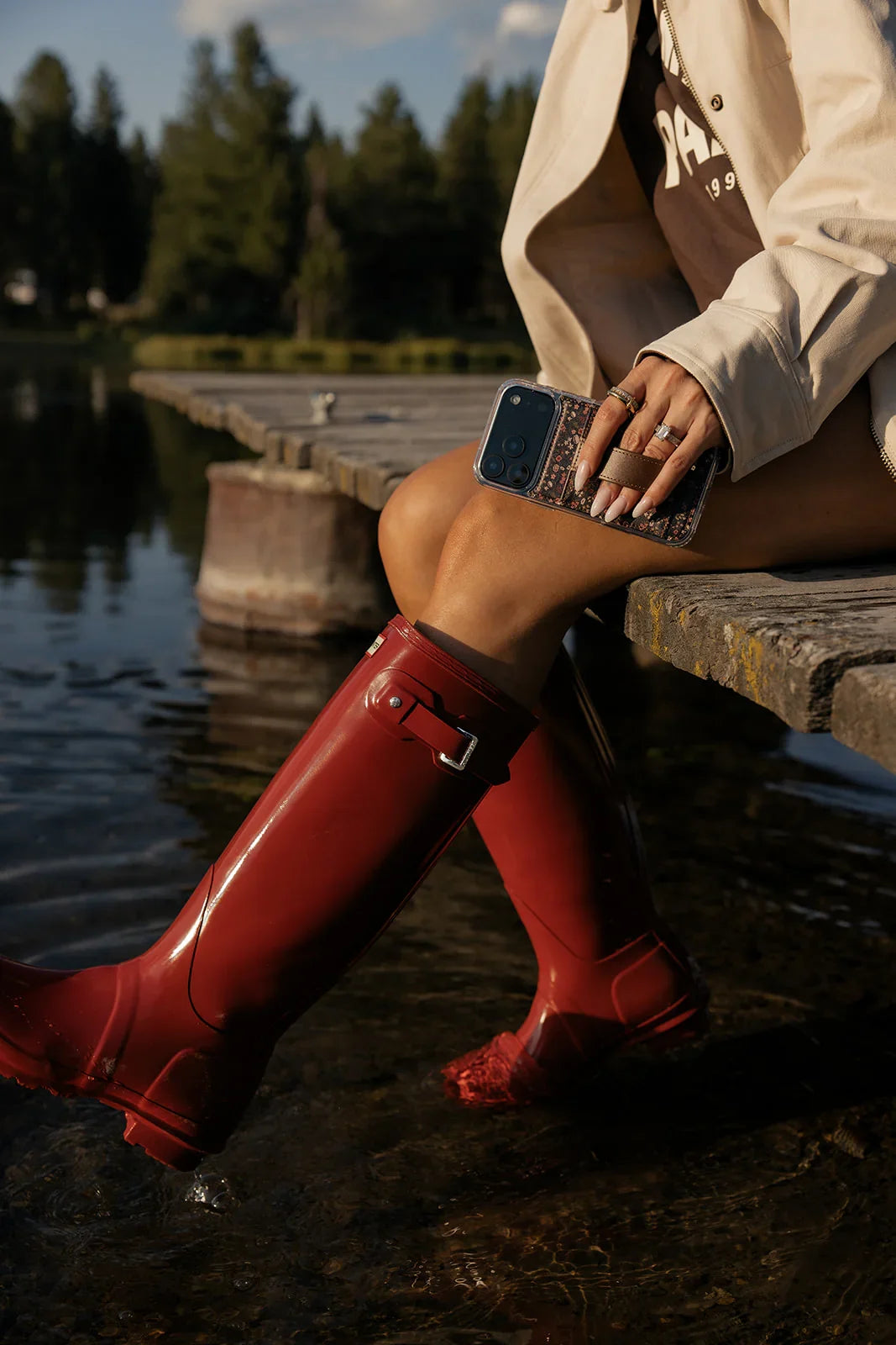 Floral phone case with brown strap pocket held by a seated person