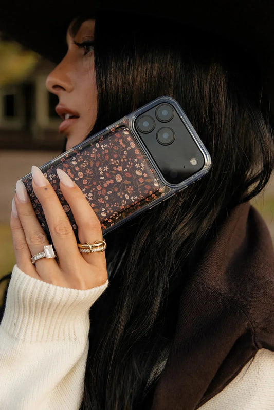 Floral phone case with clear frame, held in hand