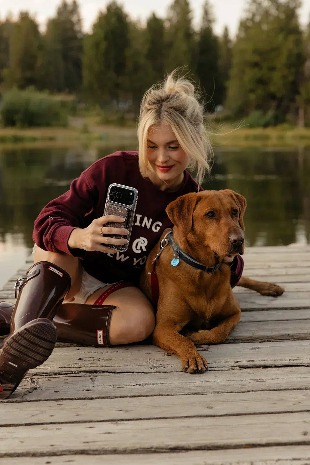 Phone case with dark floral pattern on smartphone, held outdoors