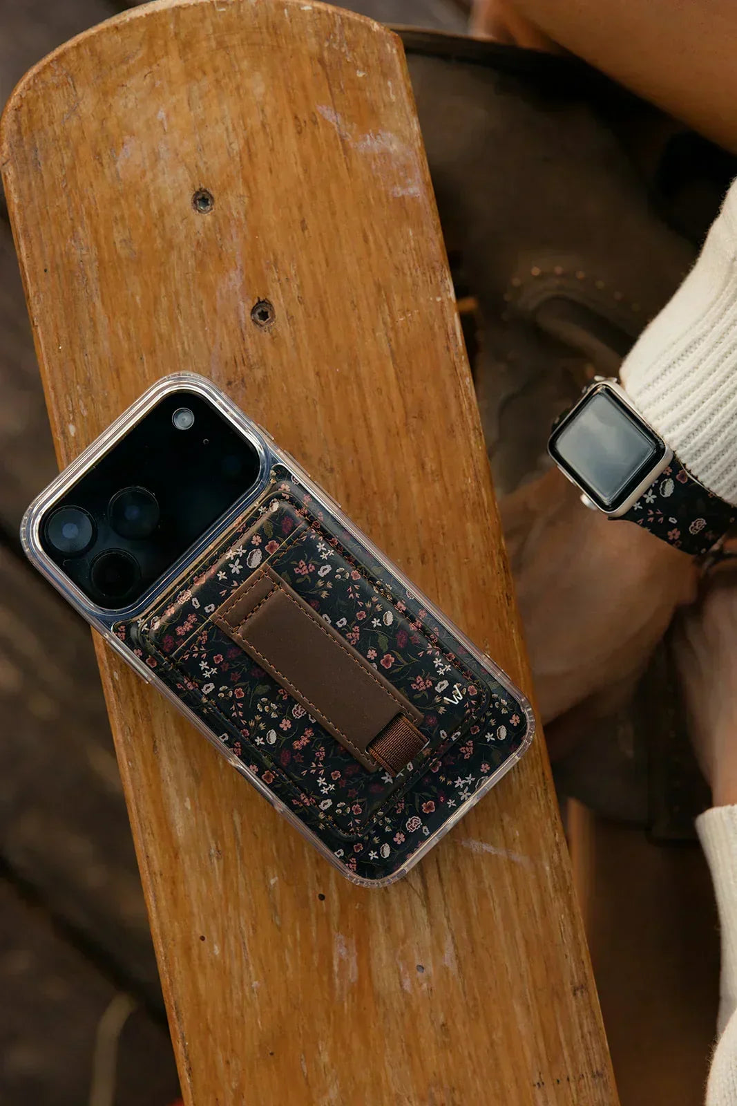 Magnetic iPhone case with clear back and dark floral panel with strap