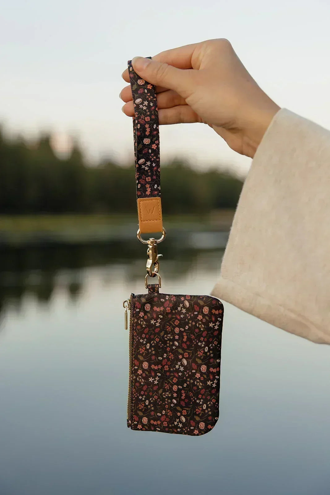 Zipper pouch with detachable crossbody strap, floral print and gold-tone hardware.