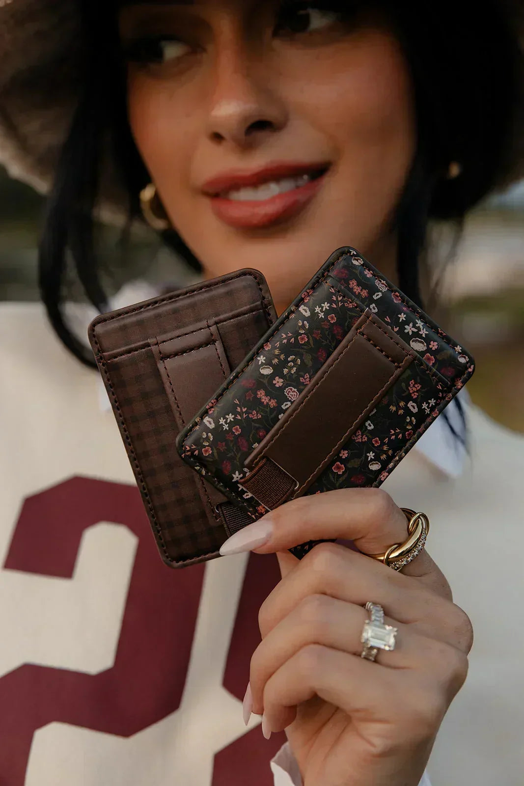 Magnetic wallet with dark floral cover, brown interior card slots, held open.