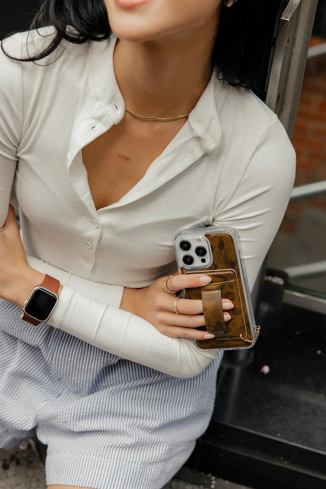Brown magnetic wallet phone case with card window, clear back, and attached strap