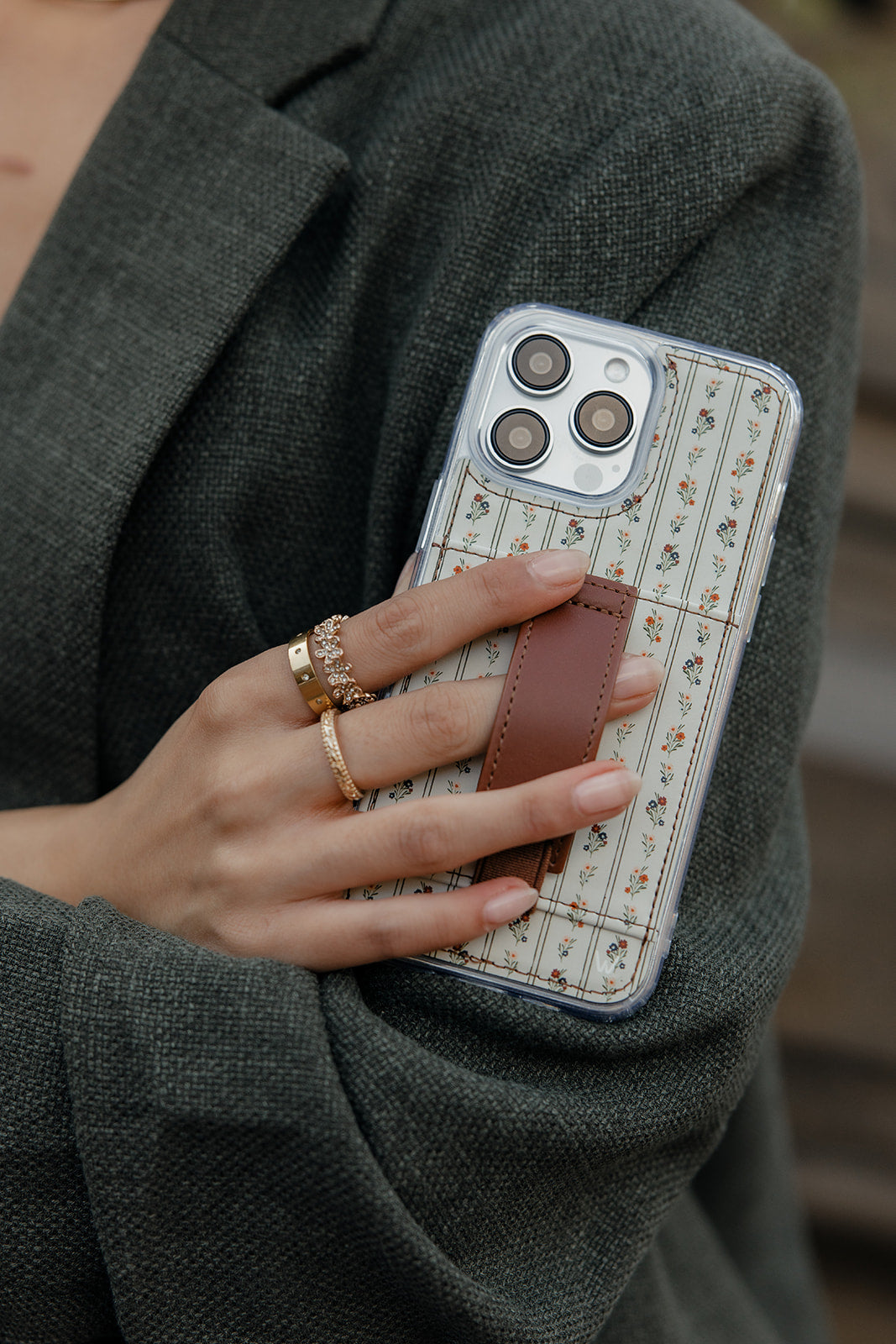 Close-up: floral clear phone case with brown leather-style strap on the back