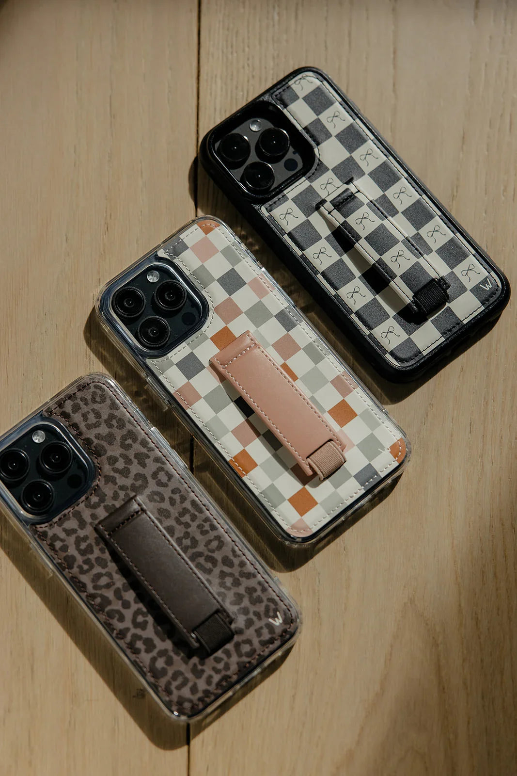 Check pattern phone case with tan strap shown with another case